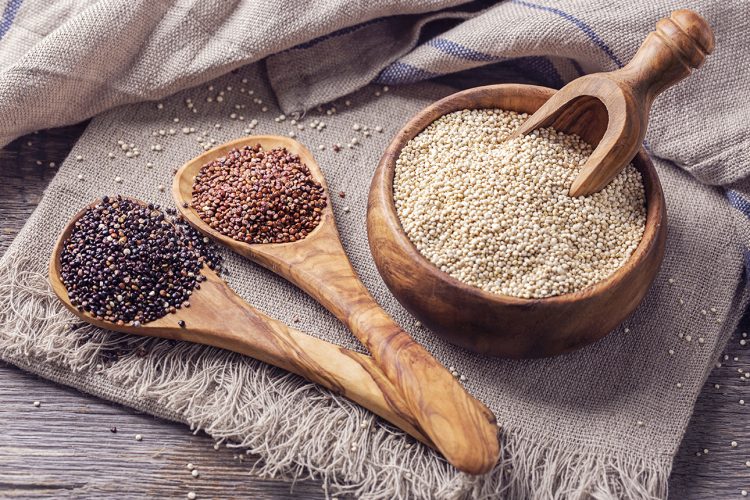 Red, black and white quinoa seeds on a white background